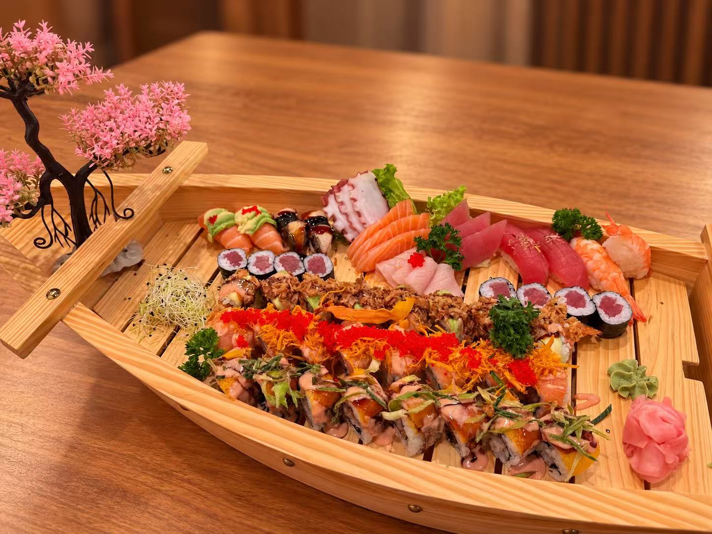 Un bateau de sushis, sashimis et rolls photographié chez CHISENYA