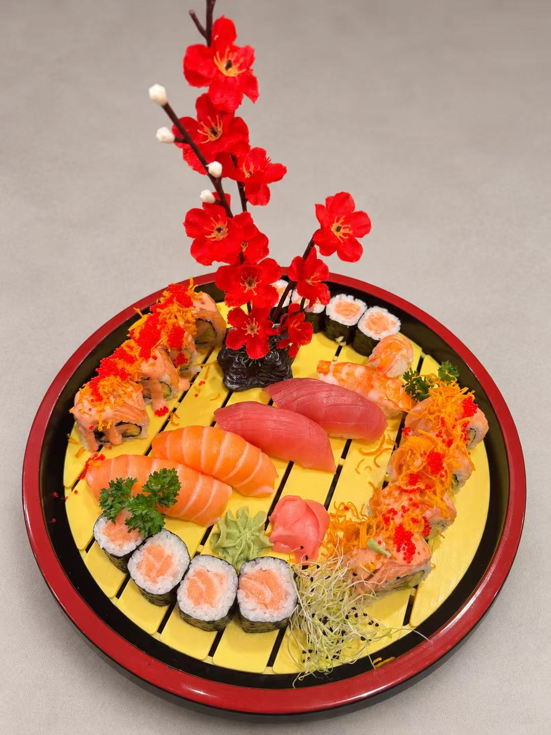 Un assortiment de nigiri et maki sur un plateau rond, préparé chez CHISENYA